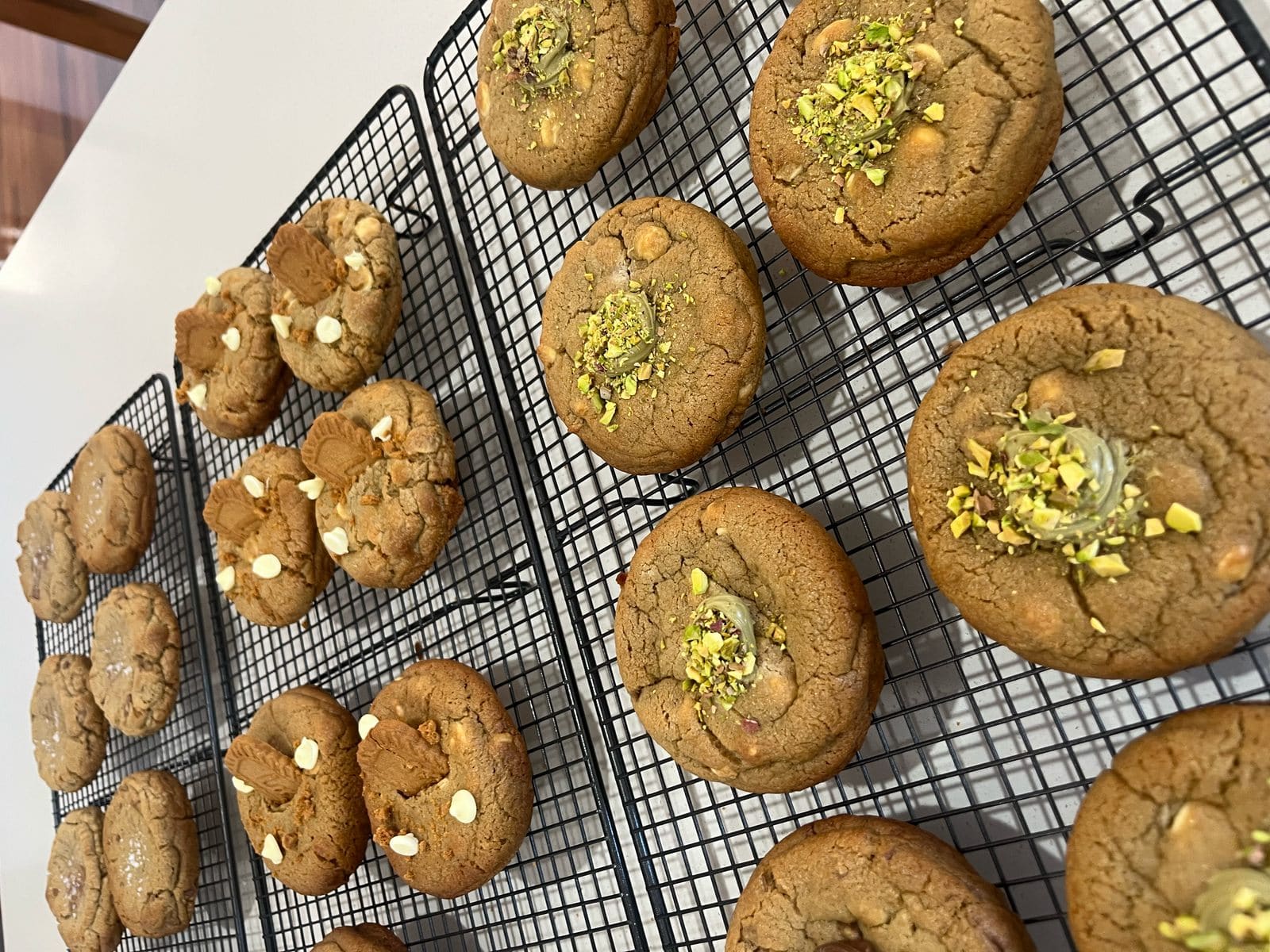 Pistachio and white chocolate cookies cooling on a rack