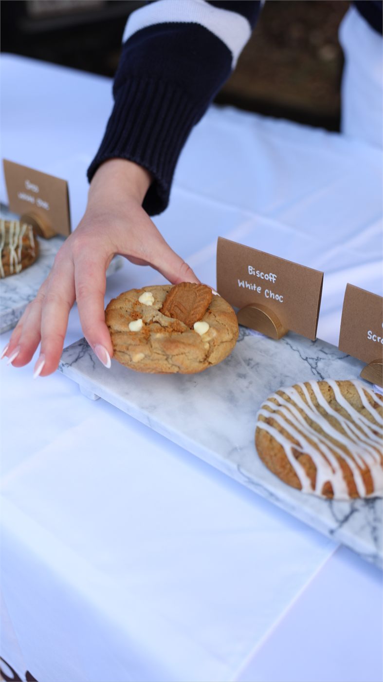 A customer picking a cookie from the Chubb market stall table